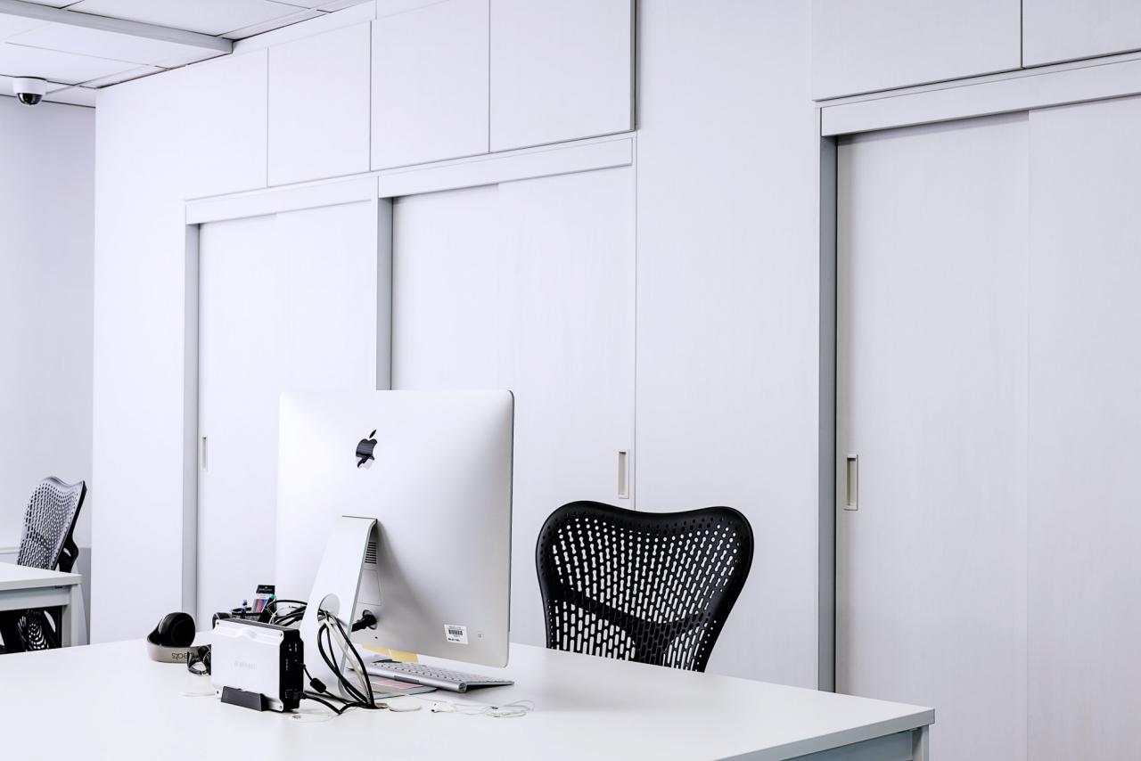 Black Mesh Office Rolling Chair Beside White Wooden Desk With ...